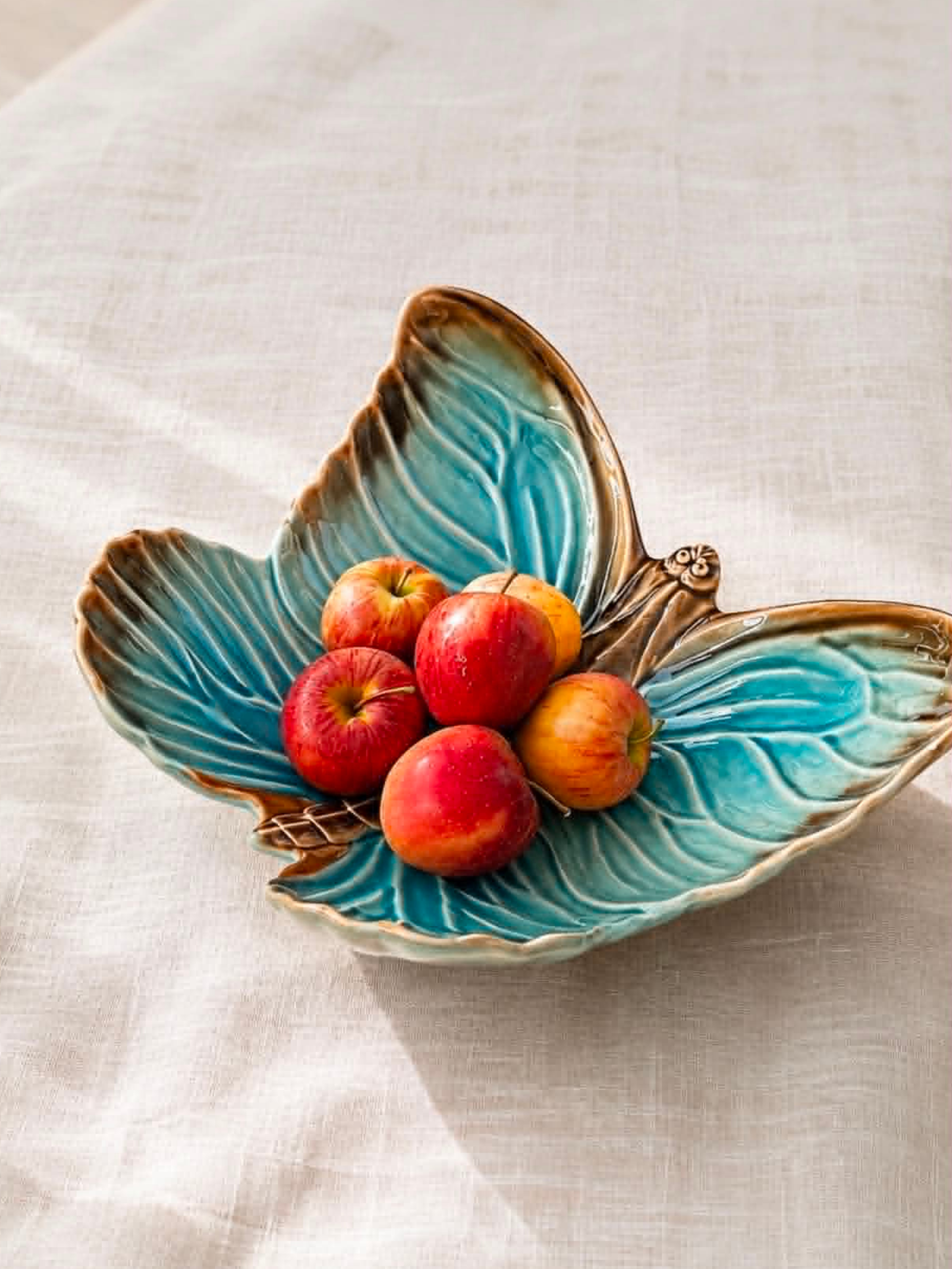 Blåt sommerfuglefad fra Cloudy Butterflies kollektionen fra Bordallo Pinheiro x Claudia Schiffer med æbler - håndlavet keramik fra Portugal