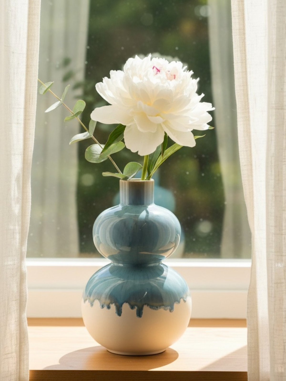 Harmonia vase fra Terrafina i blå og hvid med en enkelt blomst i vindueskarm - håndlavet porcelænsstentøj fra Portugal