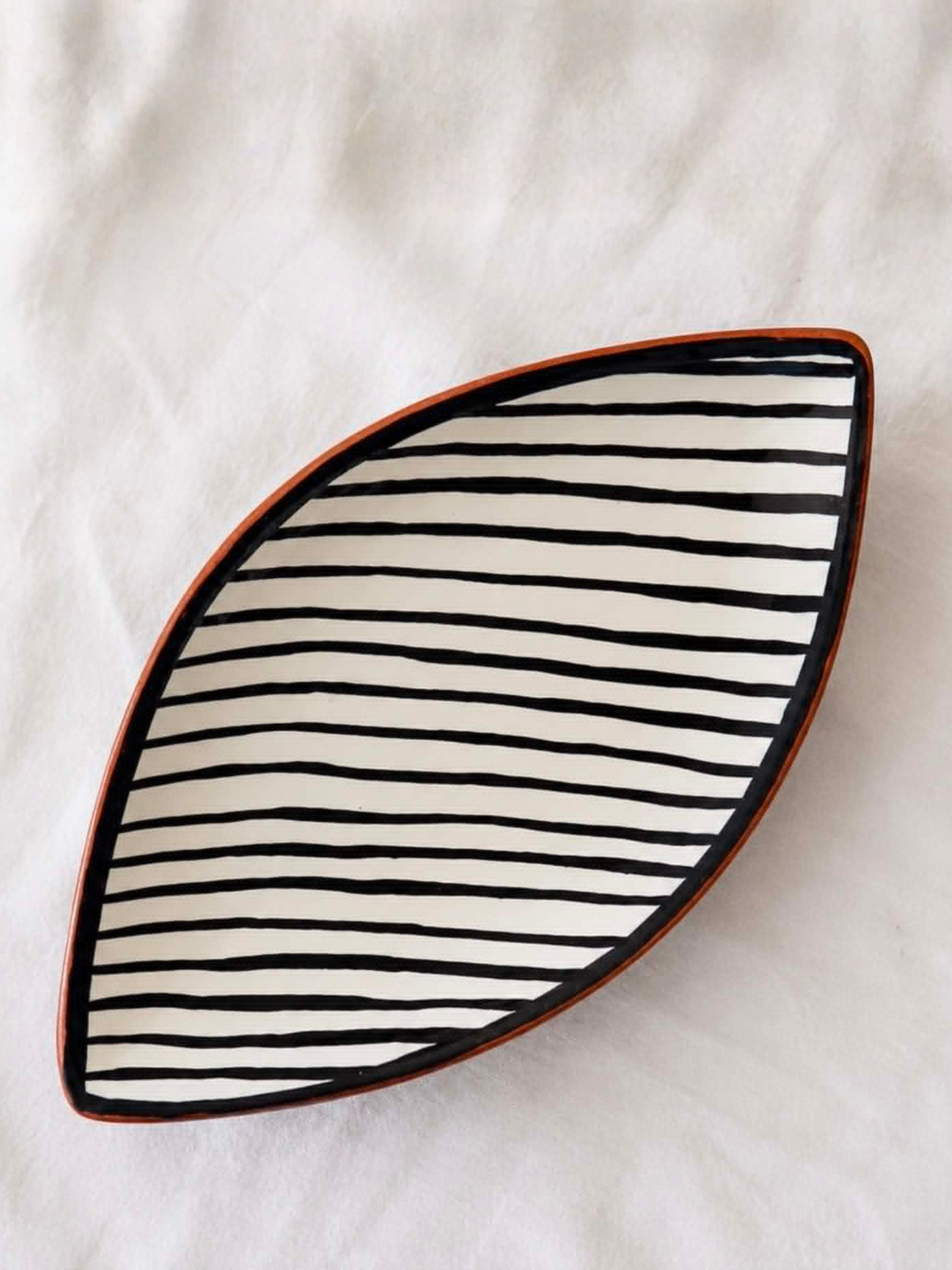 Casa Cubista Leaf fad formet som et blad med sorte og hvide striber på varm terracotta - håndlavet keramik fra Portugal