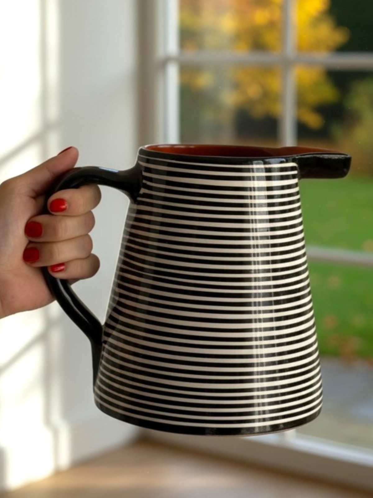 Casa Cubista Classic Stripe sortstribet kande i håndlavet terracotta fra Portugal - foran vindue