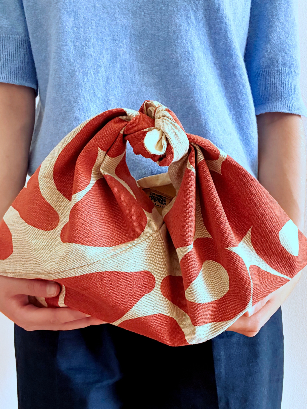 Matilde Beldroega bento bag i varm terracotta eller rødbrun, som kan bæres i hånden - håndlavet og håndtrykt i Portugal