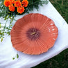 Bordallo Pinheiro Maria Flor koral valmuetallerken på havebord med hvid dug og orange blomster