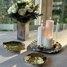 Casa Cubista Bold Stripe sort tallerkenfad med lys ved siden af guld riviera-tallerkener og blomsterbuket