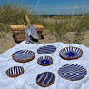 Blå Casa Cubista skåle og fade på hvidt strand picnictæppe