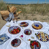 Blå Casa Cubista skåle og fade med tapas på hvidt strand picnictæppe
