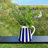 Casa Cubista Blå Bold Stripe kande med vilde blomster naturbaggrund
