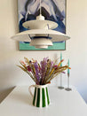 Grøn Casa Cubista Bold Stripe kande med blomster på hvidt bord under ph-lampe