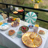 Opdækket havebord med gule Casa Cubista Ray skåle, grøn Dash skål og fad, gul Bold stripe kande, lyserød, mint og gule Grespresso-kopper