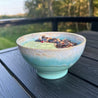 Turkis Costa Nova Latte bowl med smoothie på sort bord på terasse