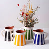 Gul, sort, blå og grøn Casa Cubista Bold Stripe kander med blomster på hvid overflade