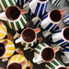 Gul, terracotta, sort, blå og grøn Casa Cubista Bold Stripe kander stablet på grå overflade